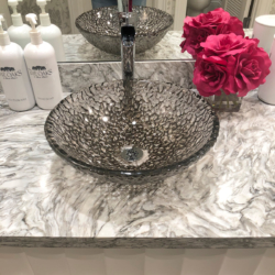 glass bowl sink with pop of pink flower accent