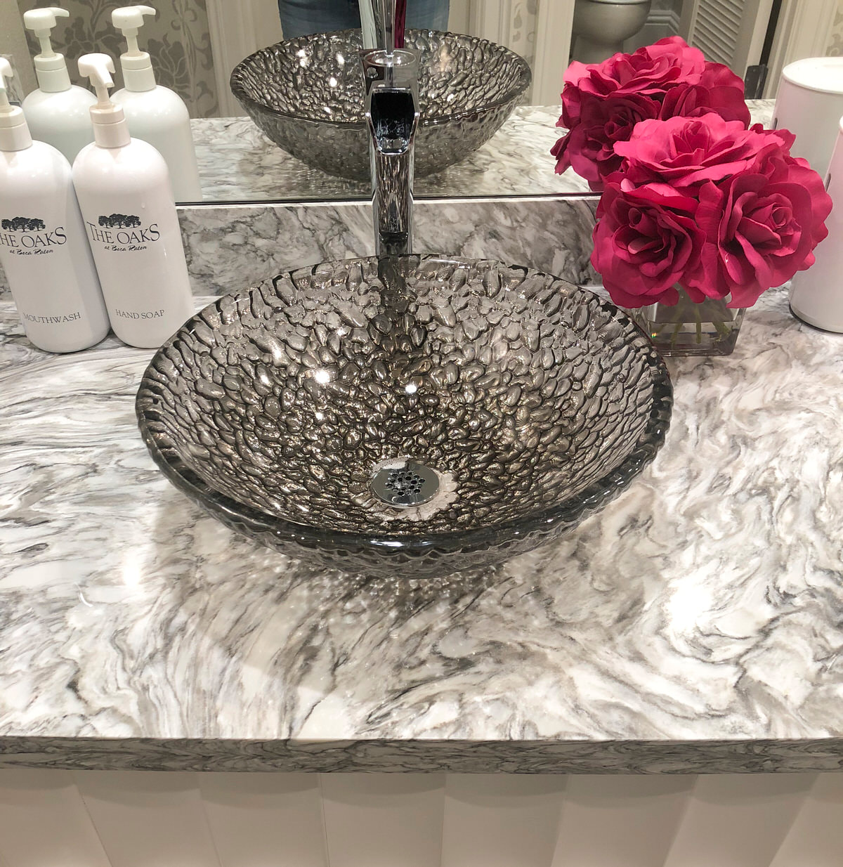 glass bowl sink with pop of pink flower accent