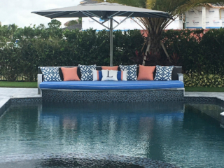 lounging area at edge of pool with umbrella